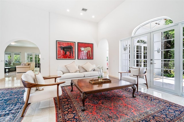 living room featuring a towering ceiling and french doors