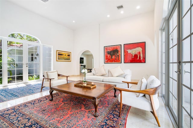 living room with a towering ceiling and french doors