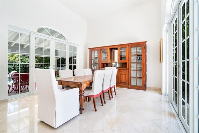 dining space with french doors and a high ceiling