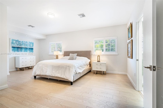 bedroom featuring multiple windows and light hardwood / wood-style flooring