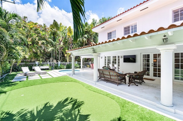 exterior space with a fenced in pool, a patio area, and french doors