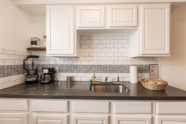 kitchen with sink, white cabinetry, and tasteful backsplash