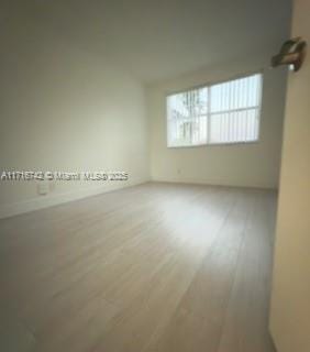 spare room featuring wood-type flooring