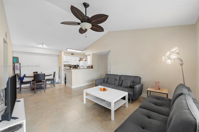 tiled living room featuring ceiling fan and vaulted ceiling