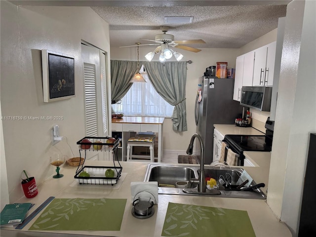 kitchen with sink, electric range, ceiling fan, a textured ceiling, and white cabinetry