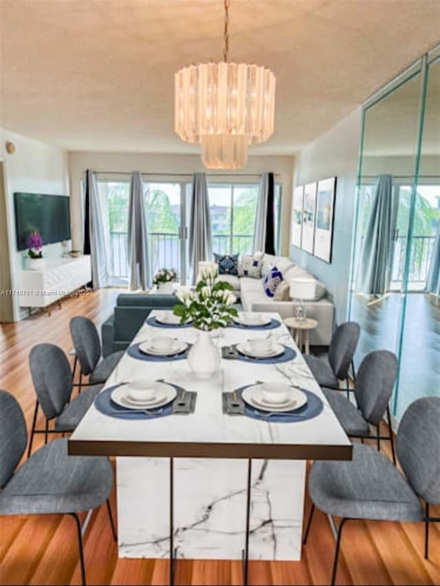 dining room featuring plenty of natural light, a chandelier, and light hardwood / wood-style floors