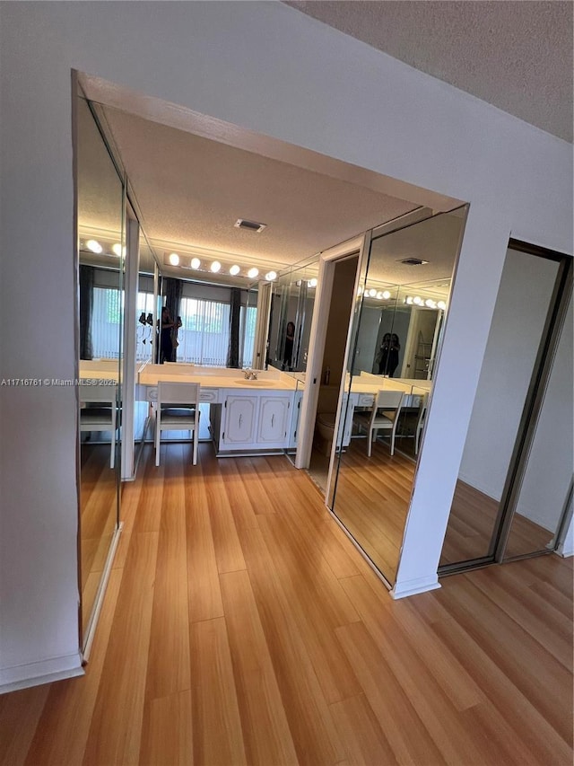 bathroom featuring hardwood / wood-style floors, vanity, a textured ceiling, and toilet