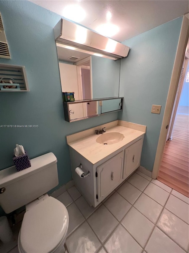 bathroom with tile patterned flooring, vanity, and toilet