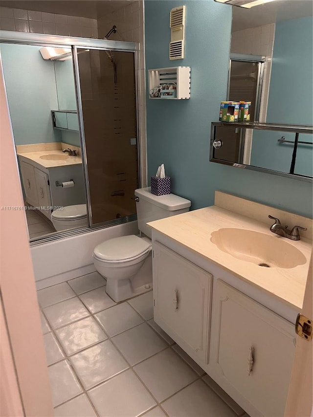 full bathroom with shower / bath combination with glass door, tile patterned floors, vanity, and toilet