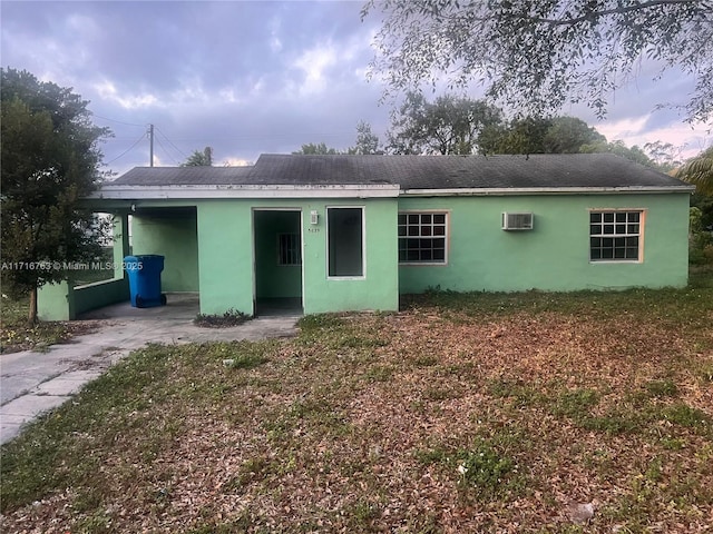 rear view of property featuring a wall mounted AC