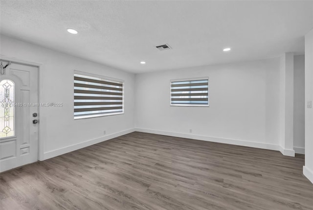 foyer entrance featuring hardwood / wood-style flooring and a textured ceiling