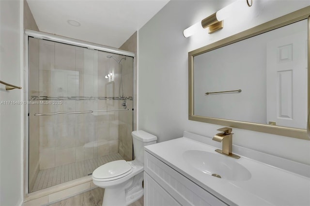 bathroom featuring hardwood / wood-style floors, vanity, toilet, and a shower with door