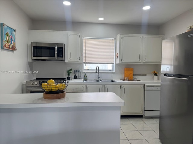 kitchen featuring stainless steel appliances, white cabinetry, sink, and light tile patterned floors