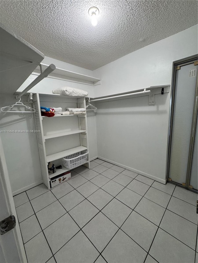 walk in closet with light tile patterned flooring