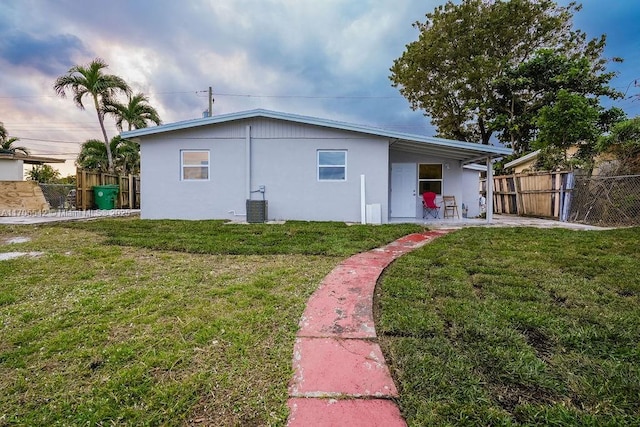 back of property with central AC and a yard