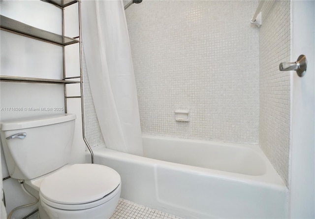 bathroom featuring shower / tub combo with curtain, tile patterned flooring, and toilet