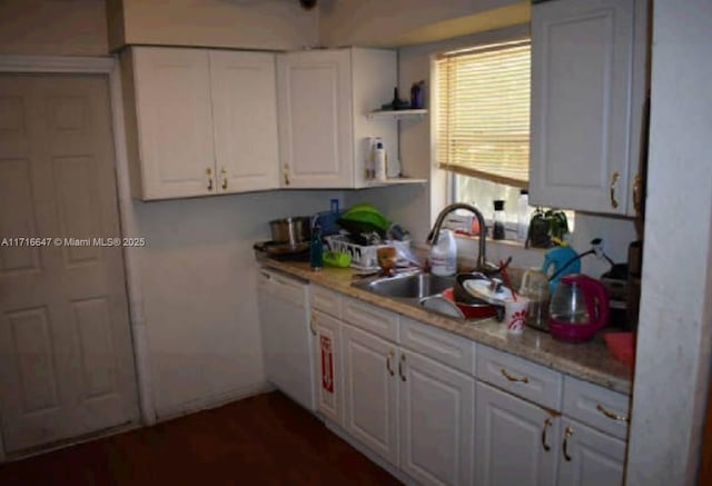 kitchen featuring white dishwasher, white cabinetry, and sink