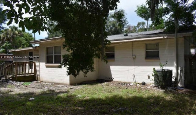 back of property with central AC unit and a deck