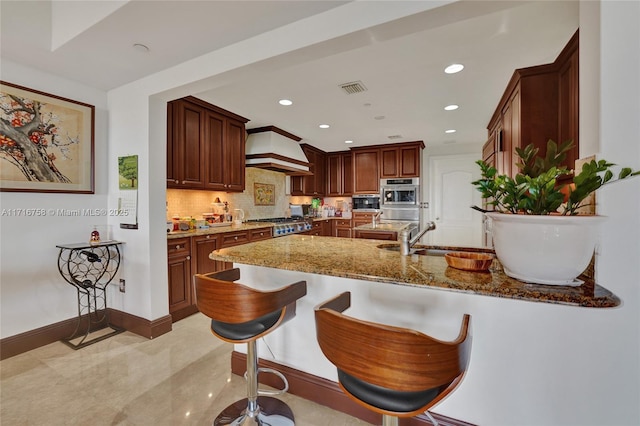 kitchen with custom exhaust hood, sink, dark stone countertops, appliances with stainless steel finishes, and kitchen peninsula