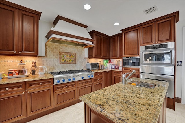 kitchen featuring light stone countertops, appliances with stainless steel finishes, tasteful backsplash, custom exhaust hood, and sink