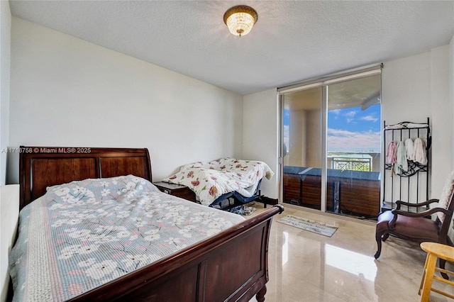 bedroom with access to exterior and a textured ceiling