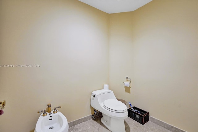 bathroom featuring tile patterned flooring, a bidet, and toilet