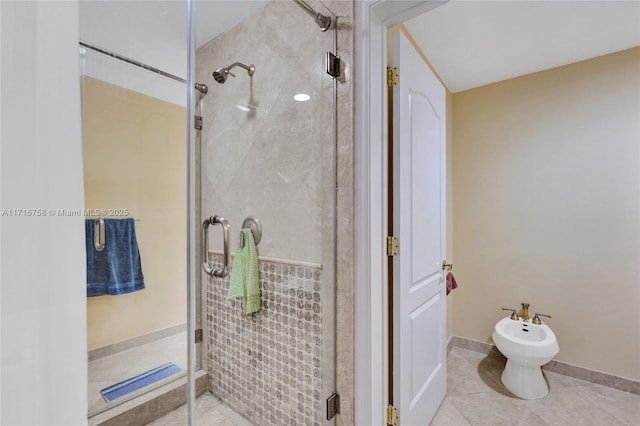 bathroom with tile patterned flooring, a shower with shower door, and a bidet