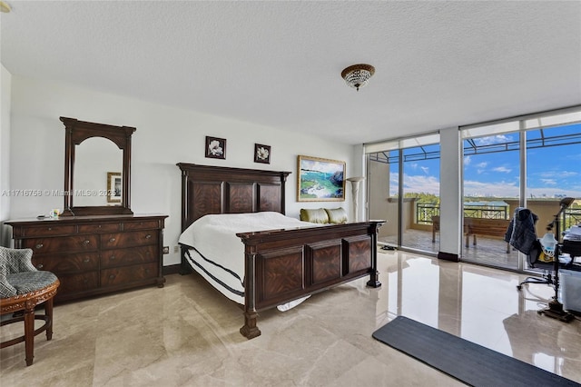 bedroom featuring floor to ceiling windows, a textured ceiling, and access to exterior