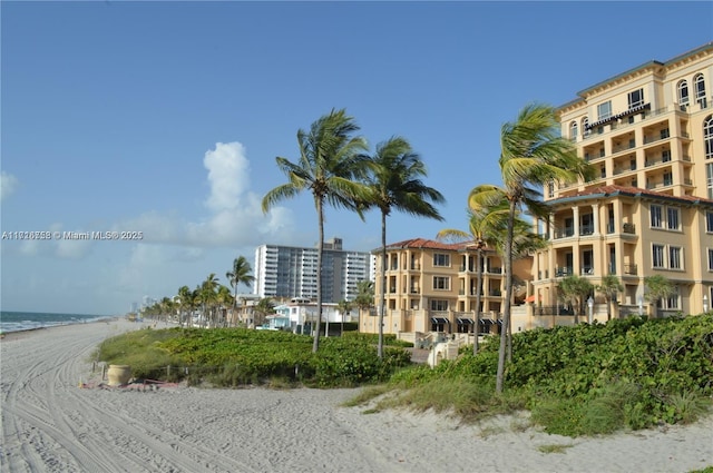 view of property featuring a water view and a beach view