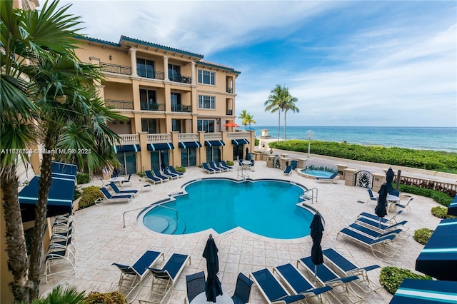 view of pool with a water view and a patio