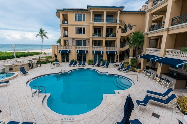 view of swimming pool with a water view and a patio