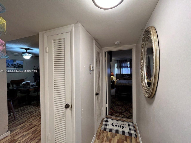 corridor with hardwood / wood-style flooring