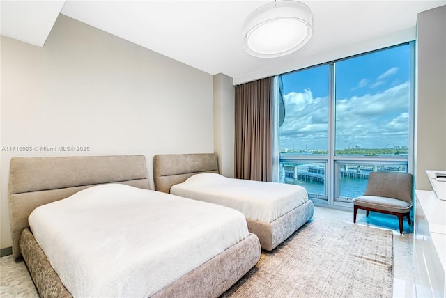 bedroom with access to exterior, floor to ceiling windows, and a water view