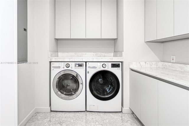 laundry area featuring cabinets and washer and clothes dryer