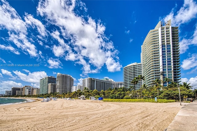 view of property with a water view and a beach view