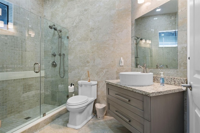 bathroom with toilet, a shower with door, tile walls, and vanity