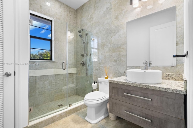 bathroom with toilet, an enclosed shower, tile walls, and vanity