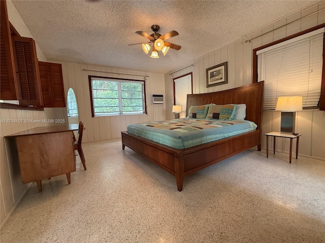 bedroom with an AC wall unit, ceiling fan, and wooden walls