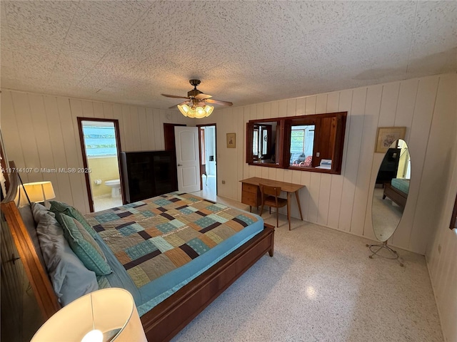 bedroom with a textured ceiling, ensuite bathroom, and ceiling fan