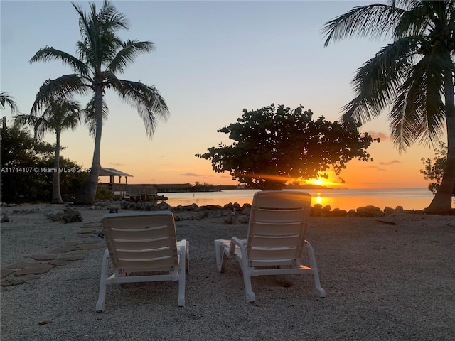 yard at dusk featuring a water view