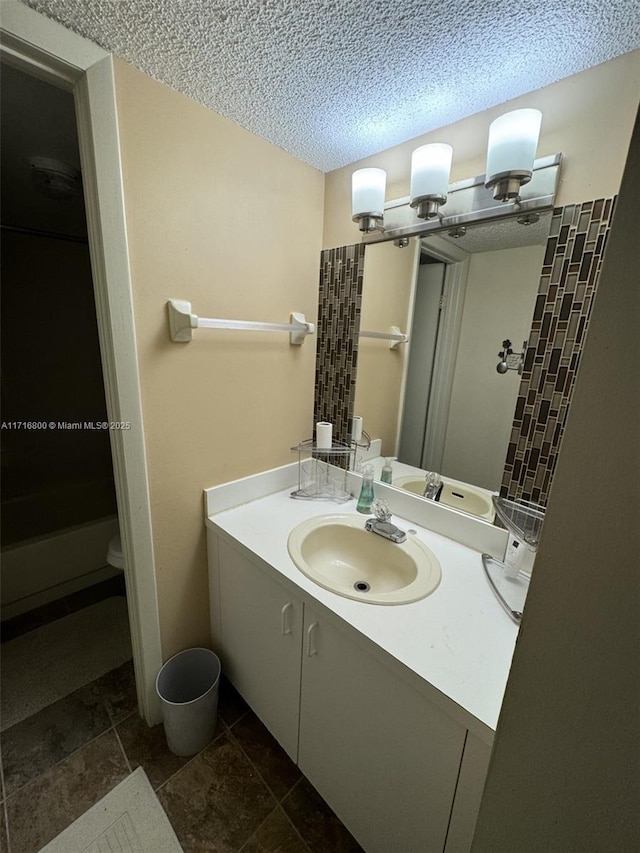 bathroom featuring vanity, toilet, and a textured ceiling