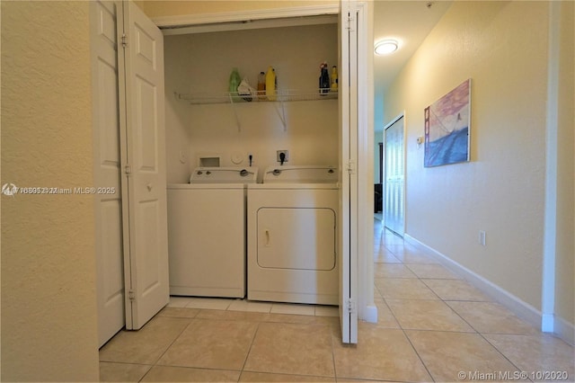 clothes washing area featuring separate washer and dryer and light tile patterned floors