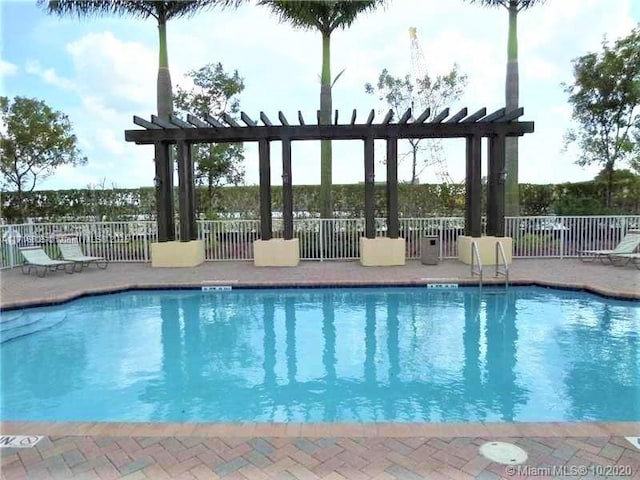 pool with a patio area, a pergola, and fence