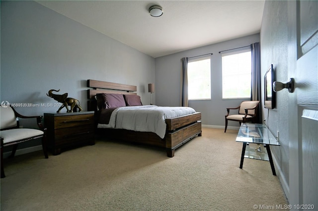 bedroom featuring light carpet and baseboards