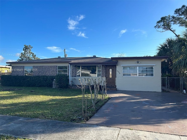 ranch-style house with a front yard, driveway, fence, and stucco siding