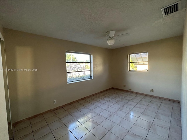 unfurnished room with a ceiling fan, visible vents, plenty of natural light, and a textured ceiling