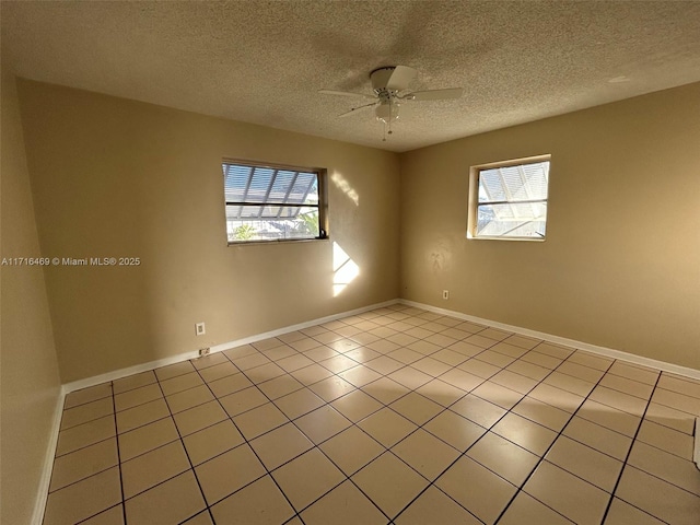 unfurnished room with a ceiling fan, a wealth of natural light, baseboards, and light tile patterned floors