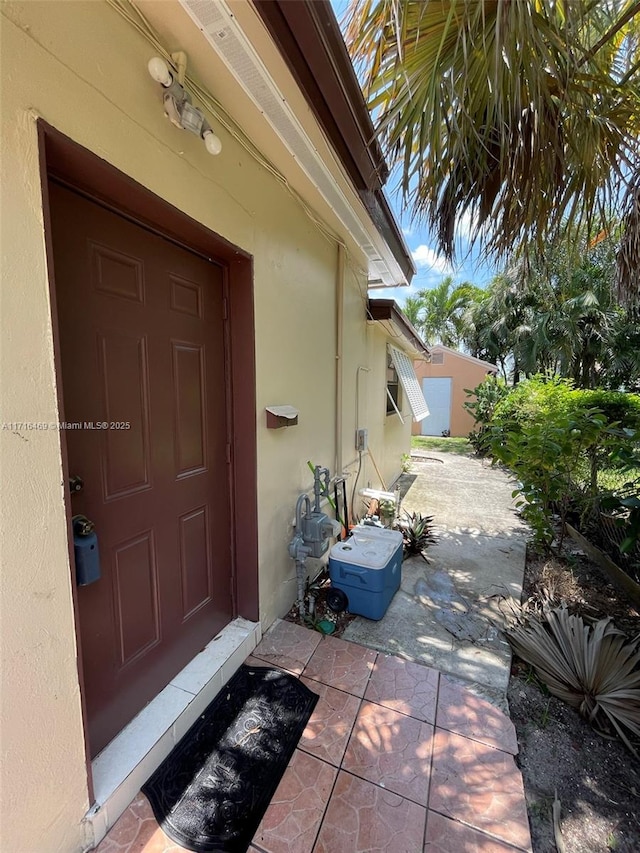 doorway to property featuring a patio area and stucco siding