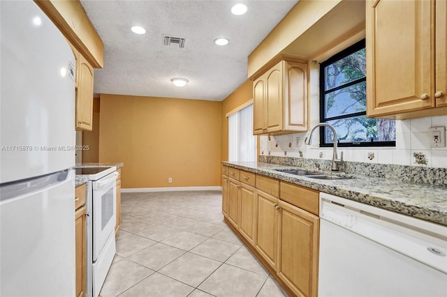 kitchen featuring light brown cabinets, white appliances, sink, a textured ceiling, and light tile patterned flooring