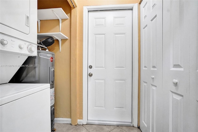 laundry area featuring stacked washer and dryer and light tile patterned floors